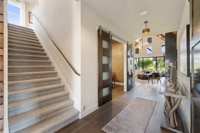 217 Northcrest Dr, Liberty Hill, TX 78642 - stairway featuring a barn door, wood finished floors, and baseboards