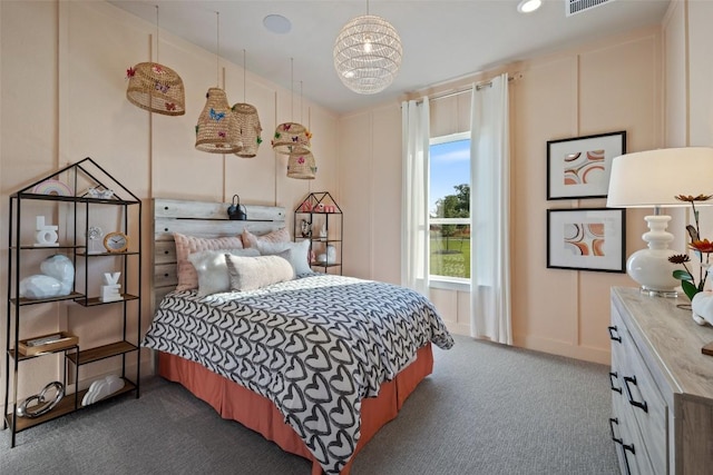 217 Northcrest Dr, Liberty Hill, TX 78642 - bedroom with dark colored carpet, a decorative wall, and a chandelier