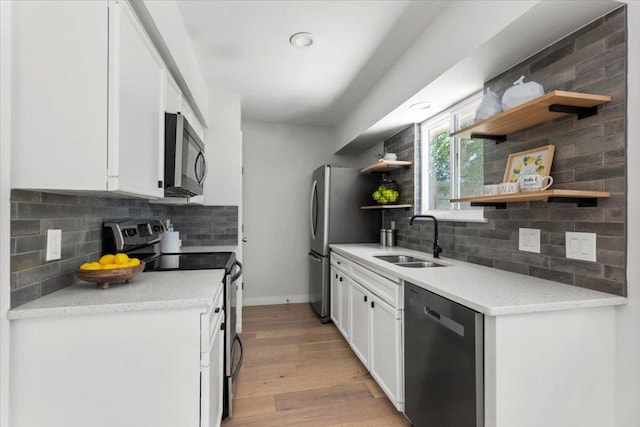 2312 Aldford Dr, Austin, TX 78745 - kitchen featuring stainless steel appliances, open shelves, light wood-style floors, backsplash, and white cabinets