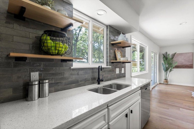 2312 Aldford Dr, Austin, TX 78745 - kitchen featuring open shelves, stainless steel dishwasher, white cabinetry, light stone counters, and decorative backsplash