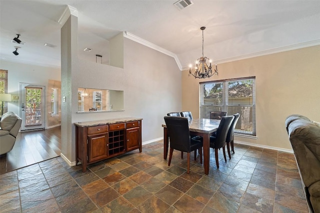 11008 Needham Ct, Austin, TX 78739 - dining area featuring ornamental molding, stone tile floors, a chandelier, and vaulted ceiling