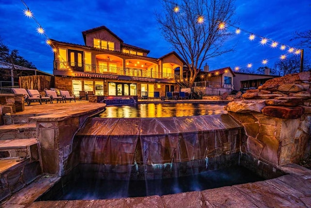 3500 River Oaks Dr, Kingsland, TX 78639 - rear view of house with a balcony, an outdoor pool, a patio, and an outdoor hot tub