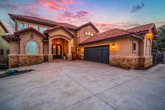 3500 River Oaks Dr, Kingsland, TX 78639 - mediterranean / spanish-style home featuring stone siding, french doors, a garage, and stucco siding
