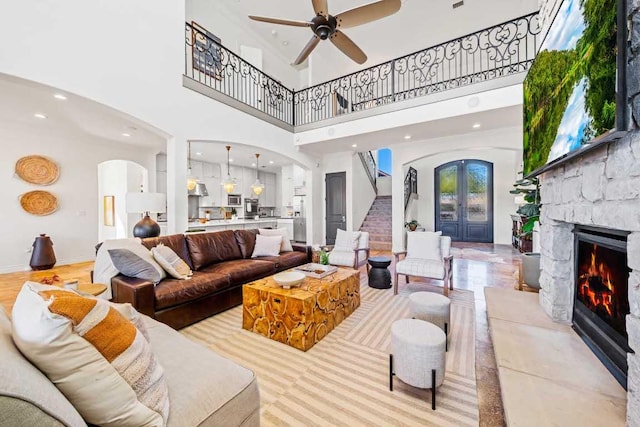 3500 River Oaks Dr, Kingsland, TX 78639 - living area with arched walkways, a towering ceiling, a fireplace, ceiling fan, and stairway
