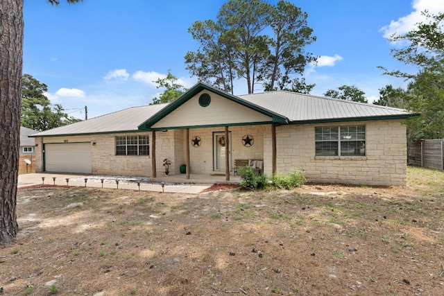 ranch-style house featuring a garage, a porch, metal roof, and fence