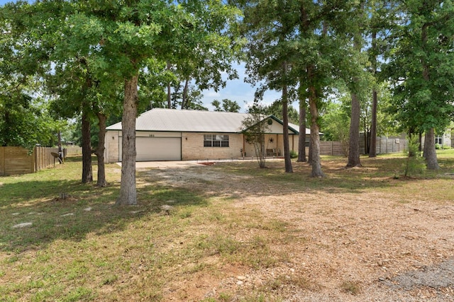 ranch-style house with a garage, driveway, and metal roof