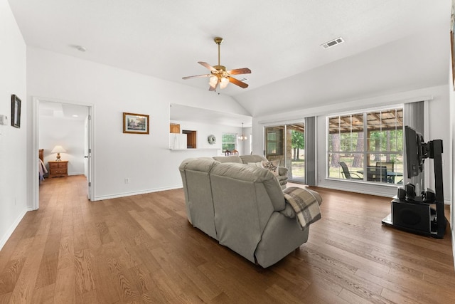 living area with ceiling fan, lofted ceiling, wood finished floors, and baseboards