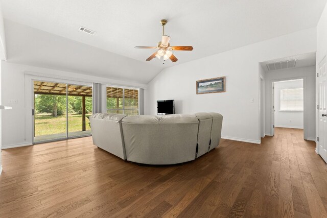 living room with a ceiling fan, wood finished floors, healthy amount of natural light, vaulted ceiling, and baseboards