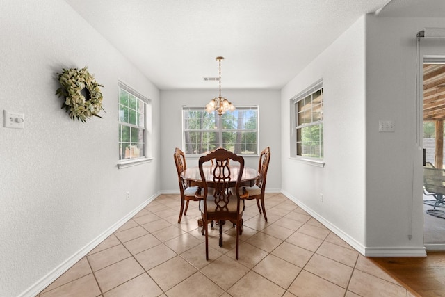 dining space featuring a chandelier, baseboards, and light tile patterned floors
