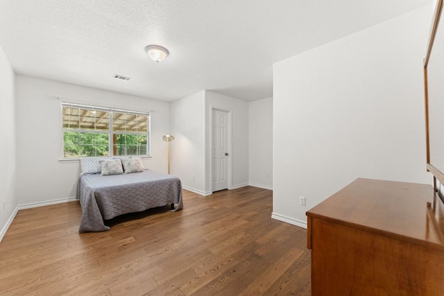 bedroom featuring wood finished floors and baseboards