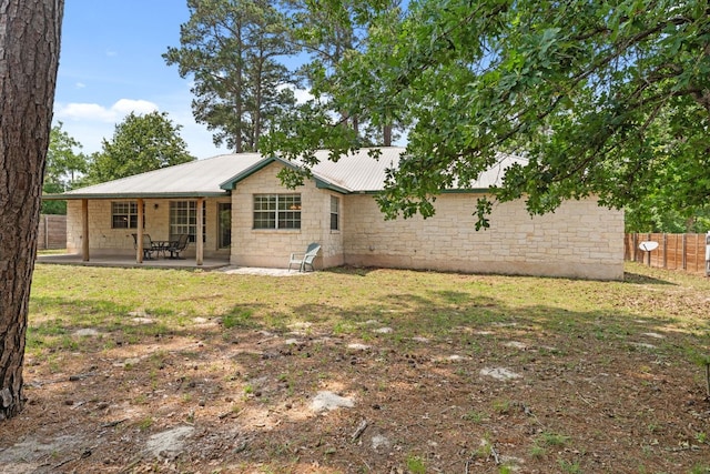 rear view of property featuring metal roof and a patio area