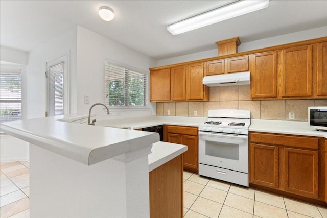 21223 Byerly Turk Dr, Pflugerville, TX 78660 - kitchen featuring white range with gas cooktop, under cabinet range hood, a peninsula, and light tile patterned floors