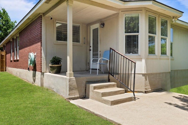 21223 Byerly Turk Dr, Pflugerville, TX 78660 - view of exterior entry featuring brick siding, a lawn, and a patio area