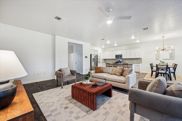 living room featuring light wood-type flooring, baseboards, a chandelier, and a ceiling fan