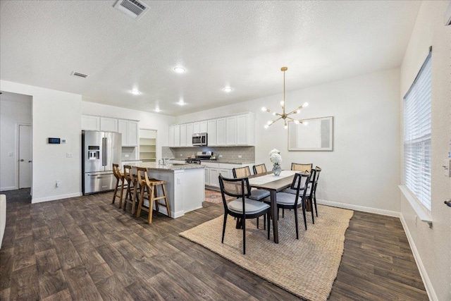 148 Feather Grass Ave, Leander, TX 78641 - dining space featuring dark wood-style floors, a chandelier, and a textured ceiling