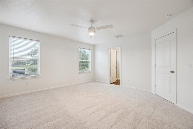 unfurnished room with carpet, a ceiling fan, and baseboards