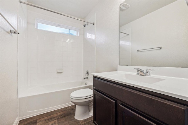 full bath featuring wood finished floors, toilet, washtub / shower combination, and vanity