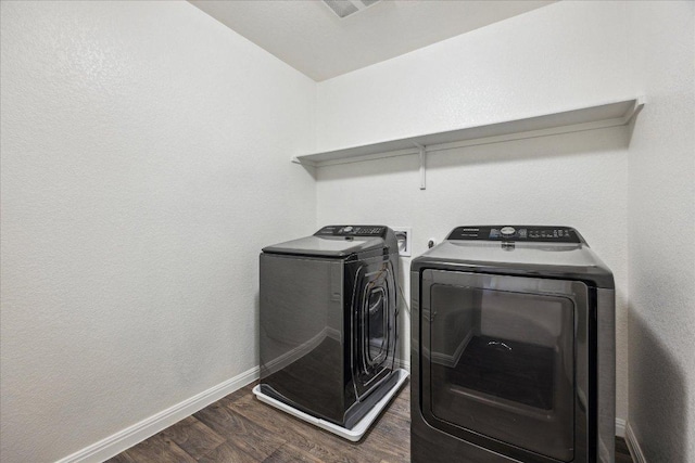 laundry area featuring separate washer and dryer, dark wood-type flooring, and baseboards