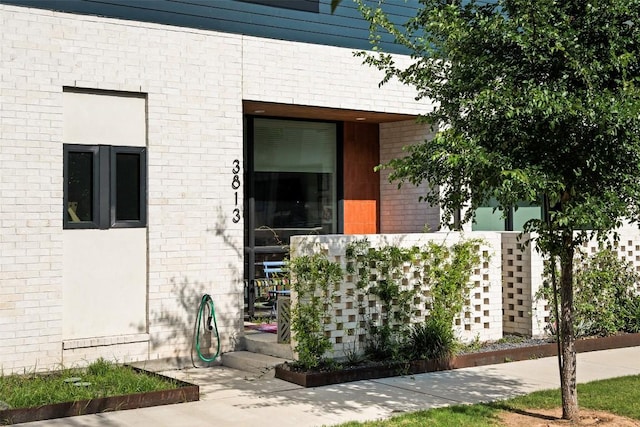 entrance to property featuring brick siding