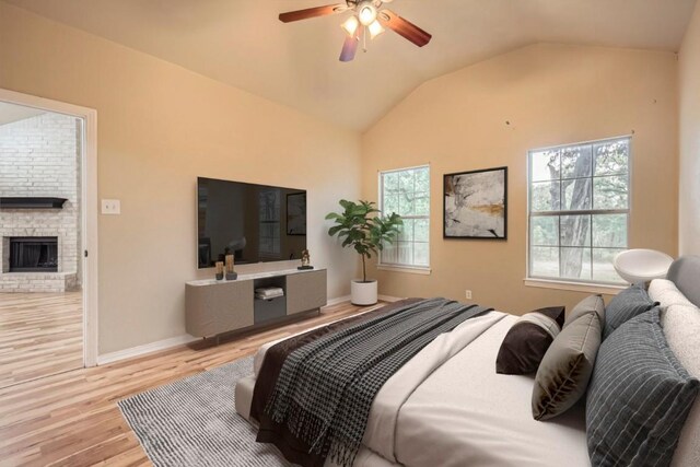 bedroom with light wood-style floors, lofted ceiling, multiple windows, a fireplace, and baseboards