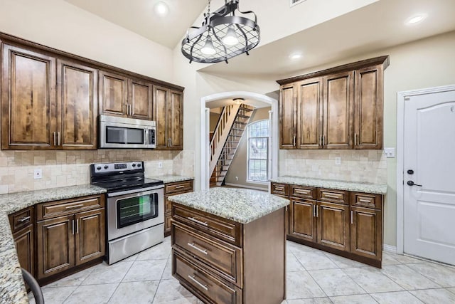 258 W Oak Loop, Cedar Creek, TX 78612 - kitchen featuring stainless steel appliances, arched walkways, light tile patterned floors, backsplash, and recessed lighting