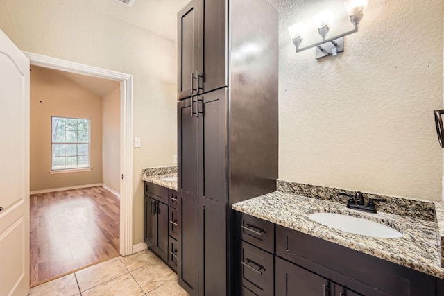 bathroom featuring vanity, tile patterned flooring, and baseboards