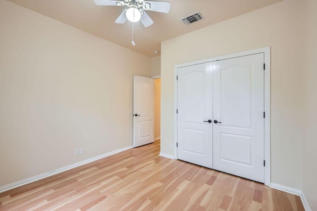 unfurnished bedroom featuring light wood-style floors, baseboards, a closet, and a ceiling fan