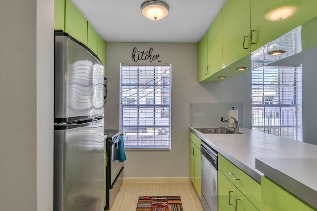 300 Crockett St Unit 210, Austin, TX 78704 - kitchen with stainless steel appliances, a sink, green cabinetry, and light wood-style flooring
