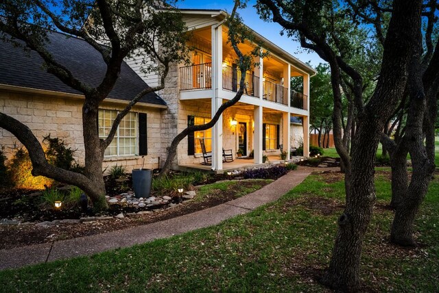 8909 Gallant Fox Rd, Austin, TX 78737 - neoclassical / greek revival house with a balcony, covered porch, stone siding, and a shingled roof