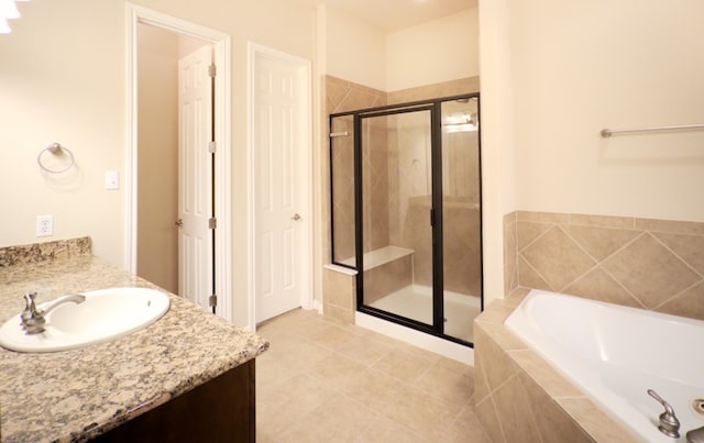full bathroom featuring a stall shower, a garden tub, vanity, and tile patterned floors