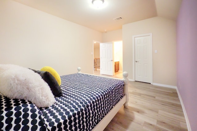 bedroom featuring light wood finished floors and baseboards