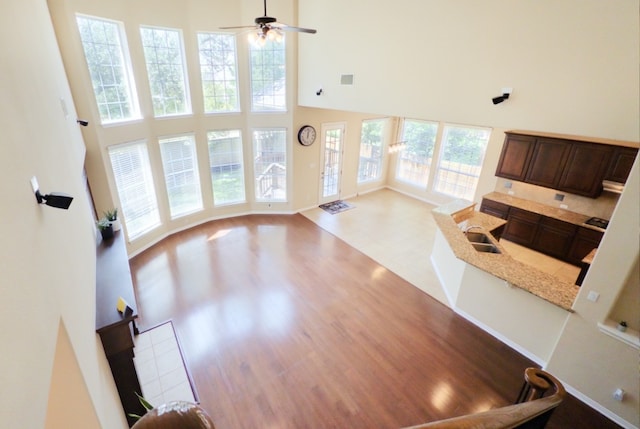 2702 Quiet Moon Trl, Cedar Park, TX 78613 - unfurnished living room featuring a towering ceiling, ceiling fan, and wood finished floors
