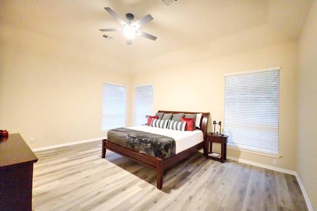 bedroom with light wood-style flooring, baseboards, and ceiling fan