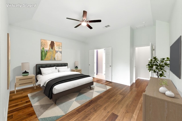 bedroom featuring wood finished floors, vaulted ceiling, and a ceiling fan