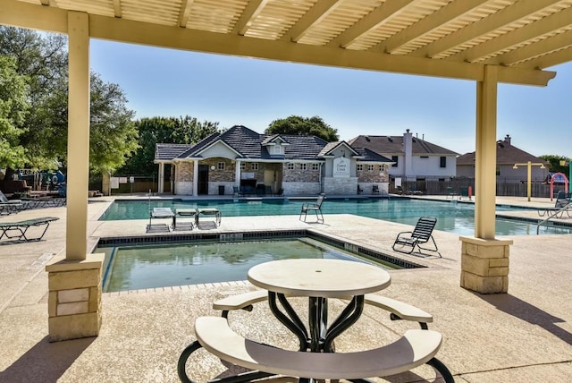 community pool featuring fence and a patio area