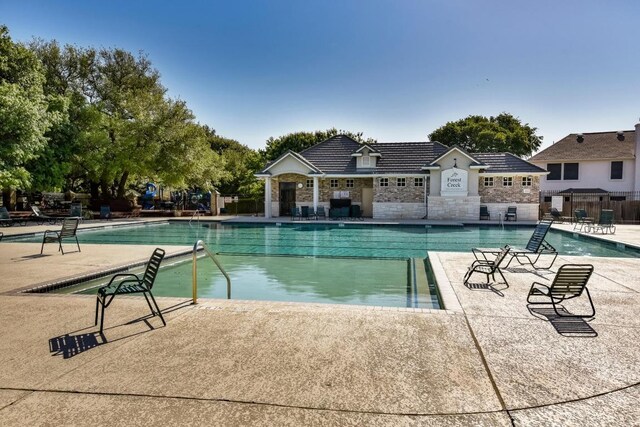 community pool with fence and a patio
