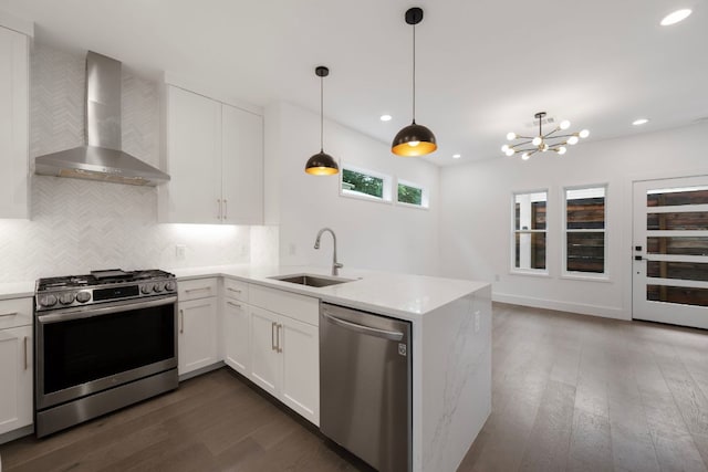 1204 W 51st St Unit 2, Austin, TX 78756 - kitchen featuring stainless steel appliances, a sink, wall chimney exhaust hood, dark wood-type flooring, and a peninsula