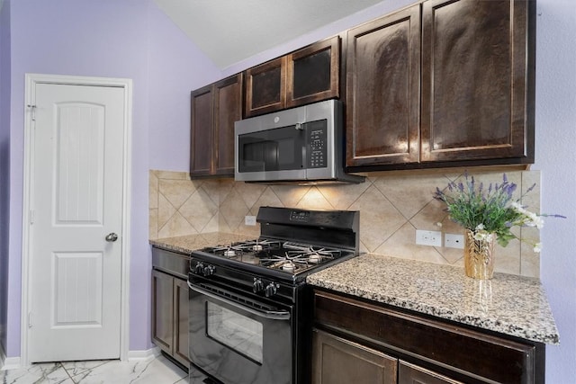 kitchen with black range with gas cooktop, stainless steel microwave, dark brown cabinetry, backsplash, and lofted ceiling