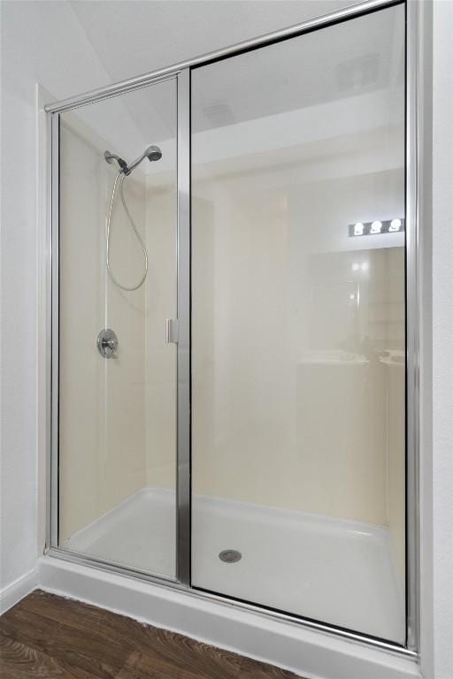 bathroom featuring a shower stall and wood finished floors