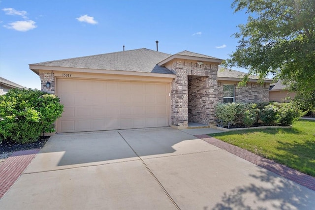 view of front of property with concrete driveway, a garage, brick siding, and a front lawn