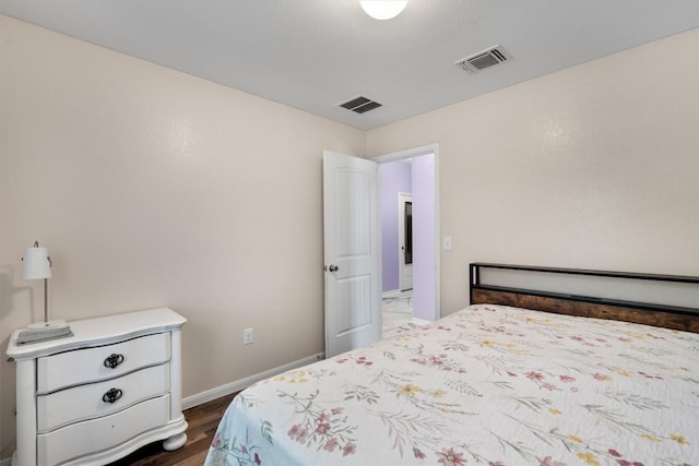 bedroom featuring baseboards and dark wood-style flooring