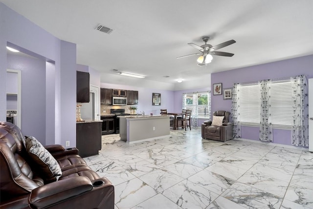 living area with a ceiling fan, light marble finish floors, and baseboards
