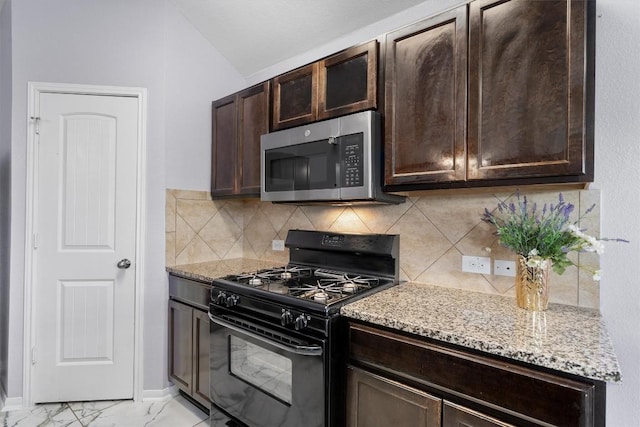 15013 Roody Ln, Austin, TX 78725 - kitchen featuring black range with gas cooktop, stainless steel microwave, dark brown cabinets, lofted ceiling, and light stone counters