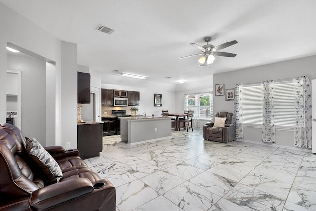 15013 Roody Ln, Austin, TX 78725 - living area with ceiling fan, light marble finish flooring, and baseboards