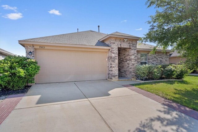 15013 Roody Ln, Austin, TX 78725 - view of front of property featuring driveway, a garage, a front lawn, and brick siding