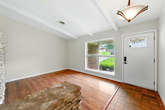 foyer featuring beam ceiling and baseboards