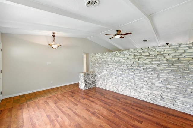 unfurnished living room featuring a ceiling fan, wood finished floors, baseboards, and brick wall