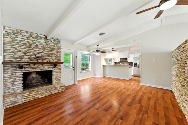 unfurnished living room featuring ceiling fan, a fireplace, light wood-style floors, and baseboards