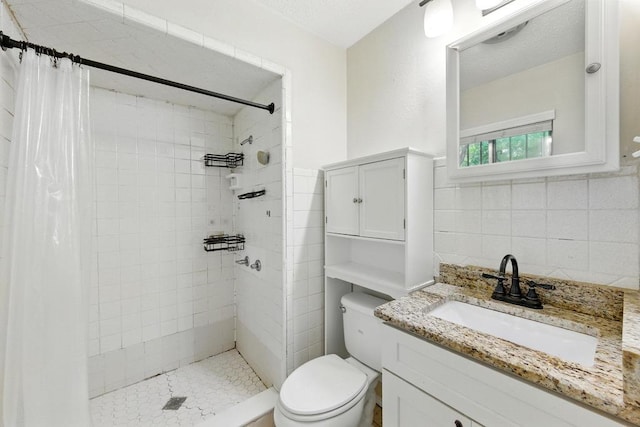 bathroom featuring a tile shower, toilet, vanity, and tile walls