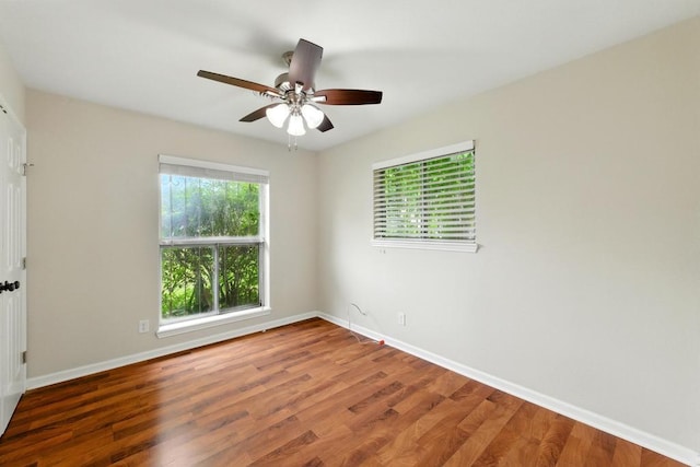 unfurnished room featuring baseboards, wood finished floors, and a ceiling fan